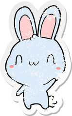 distressed sticker of a cartoon rabbit waving