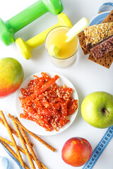 glass of celery juice, crackers and fruits, meat snacks on a plate, dried pieces of Carpaccio meat, dumbbell and sports ruler, on a white isolated background