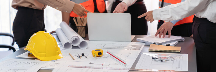 Engineer partner drawing and working on blueprint design together on office table for architectural...
