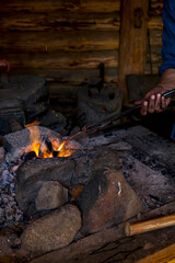 Blacksmith working metal with hammer on the anvil in the forge