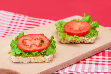Rice Cake Sandwiches with Tomato and Lettuce on Wooden Cutting Board. Easy Breakfast. Diet Food. Quick and Healthy Sandwiches. Crispbread with Tasty Filling. Healthy Dietary Snack