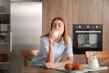 Young woman drinking milk in kitchen © Pixel-Shot