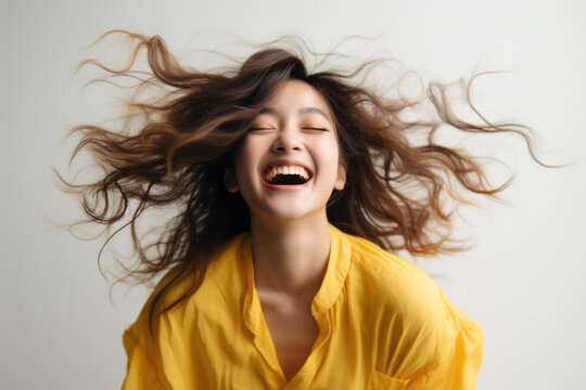 Woman standing with her hair blowing in wind. This image can be used to convey sense of freedom and natural beauty.