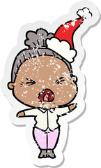 hand drawn distressed sticker cartoon of a angry old woman wearing santa hat