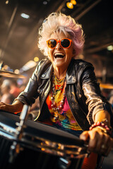 Funny elderly crazy woman in the crowd plays drums in rock concert joyful expressive