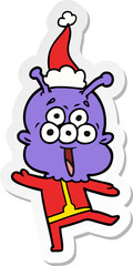 happy hand drawn sticker cartoon of a alien dancing wearing santa hat