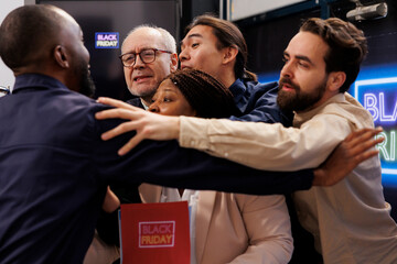 Black Friday madness. African American security guard holding back angry enger crowd while...