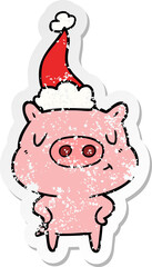 hand drawn distressed sticker cartoon of a content pig wearing santa hat