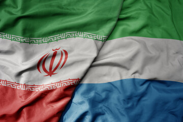 big waving realistic national colorful flag of iran and national flag of sierra leone .