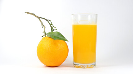 glass with orange juice and some oranges next to it, white background