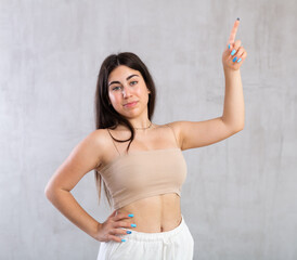 Young smiling woman in casual clothes gesturing in studio