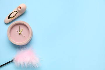 Alarm clock with sex toys on blue background