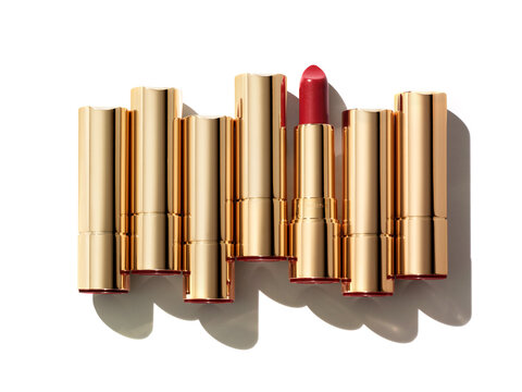 Seven lipsticks composition isolated on white background. Pink red gold cosmetic makeup product sample