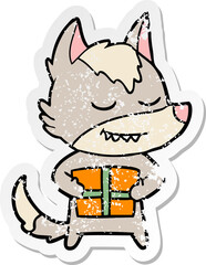 distressed sticker of a friendly cartoon wolf carrying christmas present