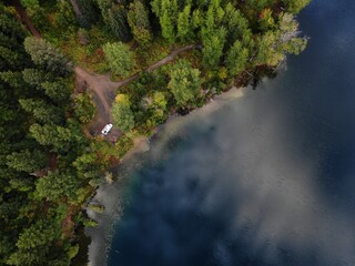Naklejka na ściany i meble Top down aerial of RV camped on edge of blue alpine lake in British Columbia