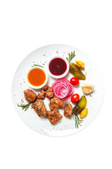 chicken kebab on a white plate with sauce and vegetables isolated