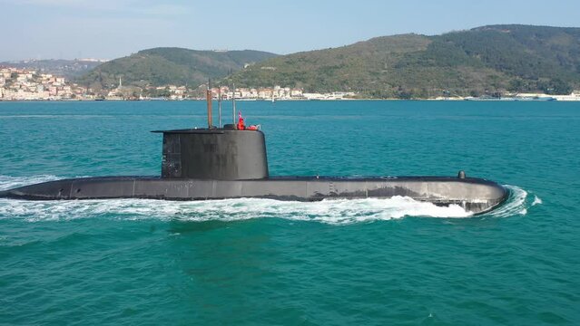 Navy submarine underway on calm waters waving the Turkish flag. Ships of impartial states can pass through Straits as during peacetime while ships of warring states prohibited from passing through
