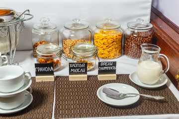Coffee, milk and cereals in glass jars on the table