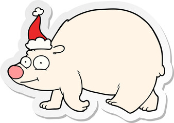 hand drawn sticker cartoon of a walking polar bear wearing santa hat