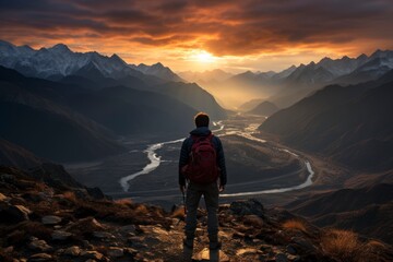 A dramatic silhouette of a lone hiker standing on a mountaintop, gazing at the expansive landscape below