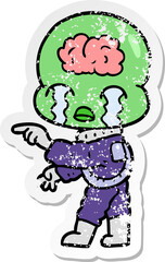 distressed sticker of a cartoon big brain alien crying and pointing