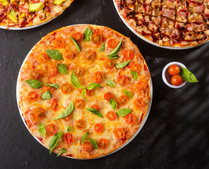 Delicious margarita pizza with small red tomatoes