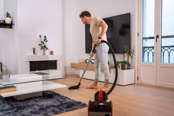 Man vacuuming the living room of a house