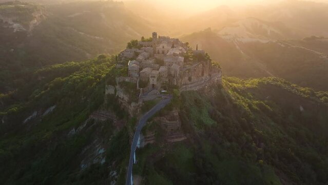 Aerial summer sunrise view of famous Civita di Bagnoregio village, located on top of a volcanic tuff hill overlooking the Tiber river valley, province of Viterbo, Lazio, Italy