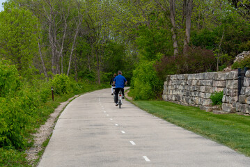 Fototapeta premium People On Bicycles Enjoying The Fox River Trail Near De Pere, Wisconsin, In Spring