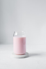 Pink milkshake in a can shaped glass, strawberry raspberry milkshake in a glass shaped like a can, Aesthetic cafe pink milkshake in a can glass