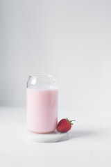 Pink milkshake in a can shaped glass, strawberry raspberry milkshake in a glass shaped like a can, Aesthetic cafe pink milkshake in a can glass
