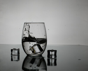 glass of water with ice cubes on a back light