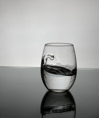 small glass of water on white background with a little splash.