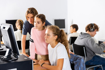 Fototapeta premium Students help each other solve problems on the computer in the classroom