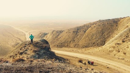 Isolated young caucasian male uphill spread hands up enjoy mountains Vashlovani national park .Famous visit destination. Achievement , inspiration, challenge and determination