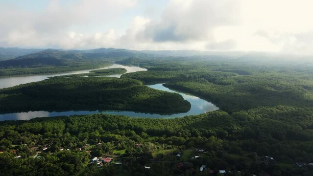 Aerial shot of a river winding through the clouds in Costa Rica, with a mix of sunshine and clouds. Beautiful contrast between the water and the jungle. Zancudo
