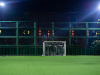 Football ground in the evening. Artificial lawn. Available infrastructure. Empty sports ground. Football game concept. Sports mesh. Entertainment in the park.  Under the lanterns