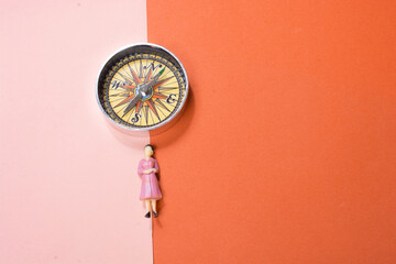 Woman figurine beside compass  as a concept of traveling