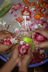 Eco-friendly Ganpati Visarjan ceremony at home. Devotees saying goodbye to Lord Ganesha with flowers in hand.