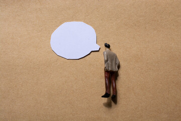 Man figurine and Mini speech bubbles cut out of paper in view