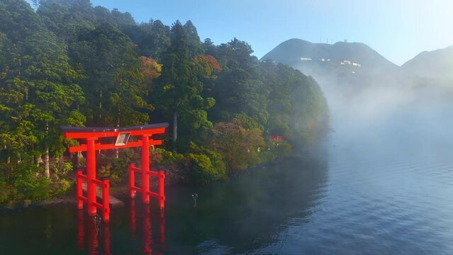 Hakone lake in Japan, tourism in Japan, Japanese culture, red torii gate on a lake on an amazing foggy morning, Japanese tourist landmark