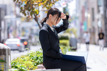 ベンチの椅子に座る女性　Business