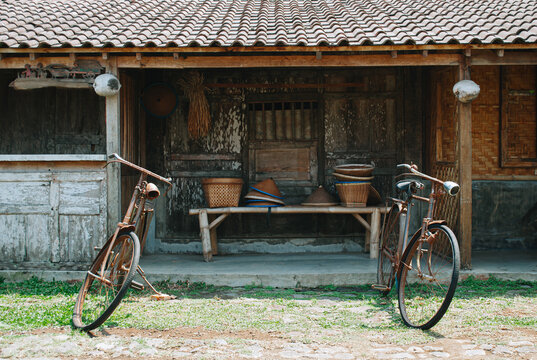 Traditional Javanese house is known as Joglo with two worn bicycles in front