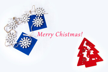 折り紙と雪の結晶と赤のクリスマスツリーのデザインとMerry Christmasのメッセージ、白背景