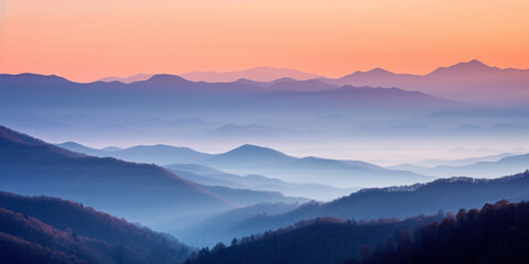 Fototapeta premium The mountains are shrouded in mist. A twilight shot of autumn mountains under a fading red orange purple sky.