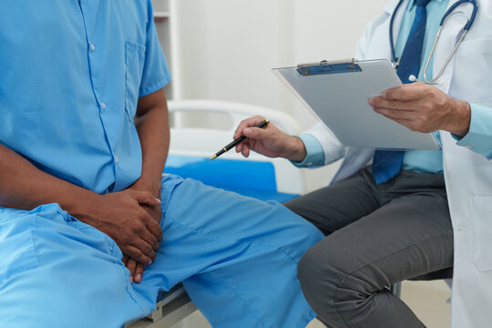A male doctor is inquiring about the testicular cancer test report of a male patient for diagnosis and planning. Providing disease control drugs medical service concept.