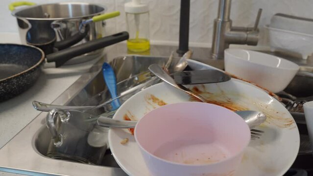 pile of dirty dishes in the kitchen sink, washing kitchenware at home
