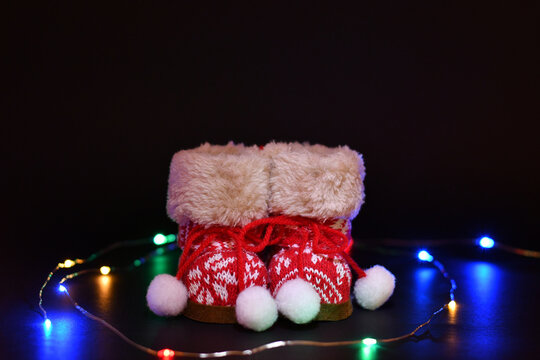 Botas de color rojo y luces de colores sobre fondo negro, concepto navide&ntilde;o. 