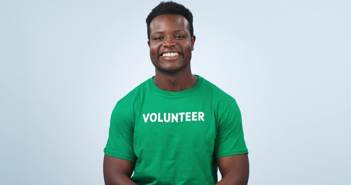 Volunteer, black man smile and face with NGO,social responsibility logo and charity tshirt in studio. Nonprofit, portrait and African male person happy from activist platform with blue background
