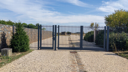 modern metal gate with an entrance door to access the driveway of the private property of suburb...